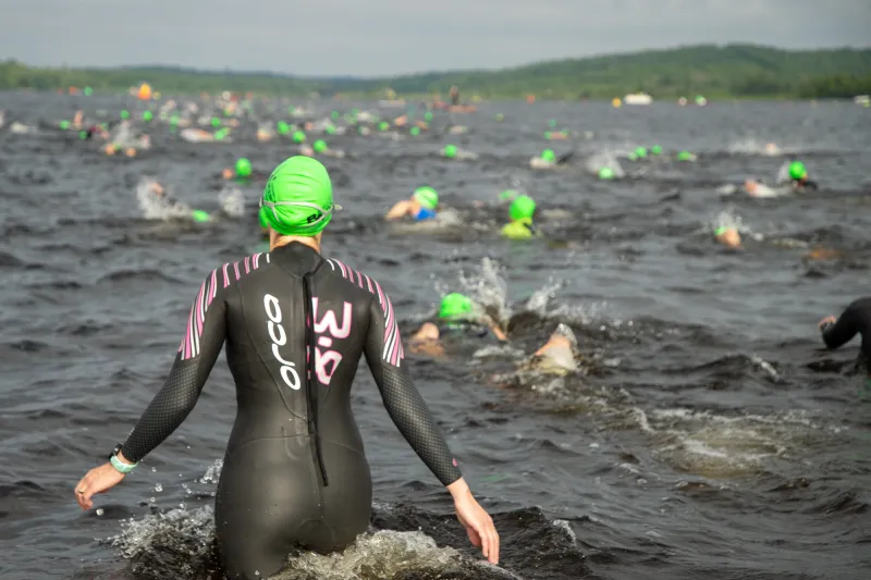 A woman joins other swimmers competing in a triathlon.