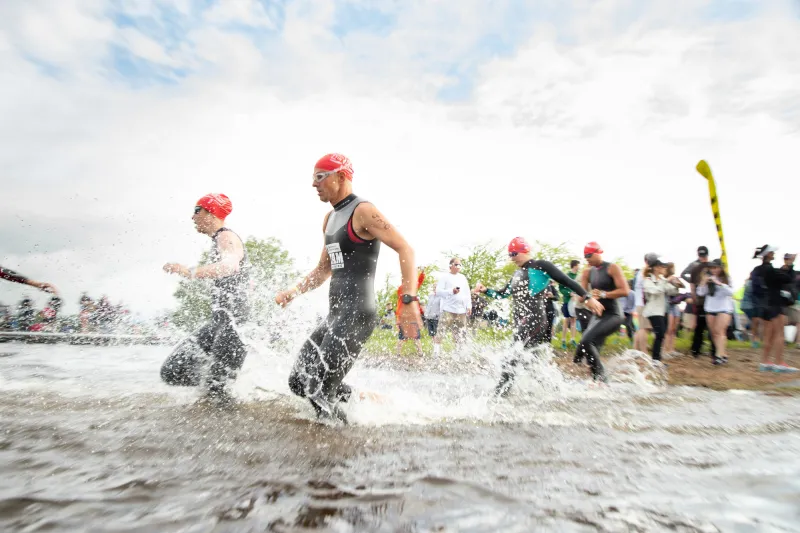 swimmers spash into the water to race.