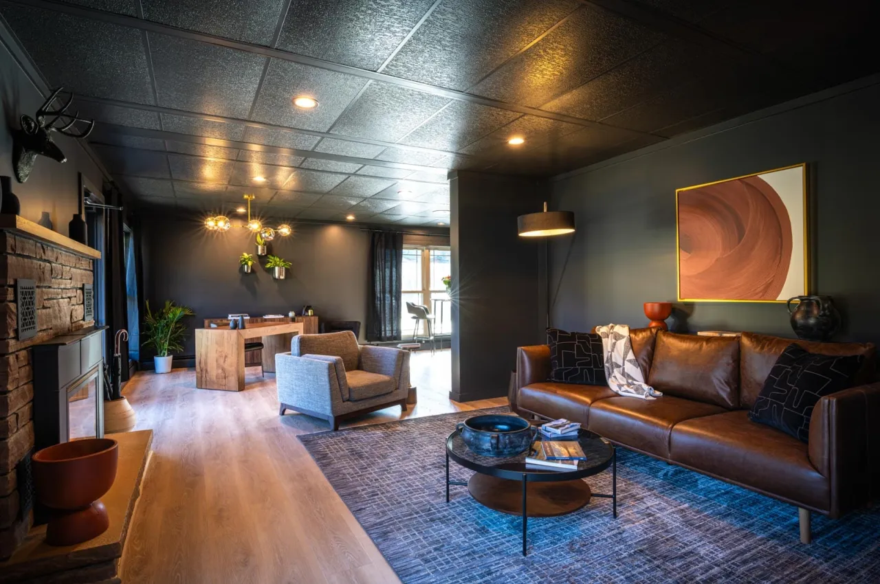 A hotel lobby with dark furniture and rustic accents. 