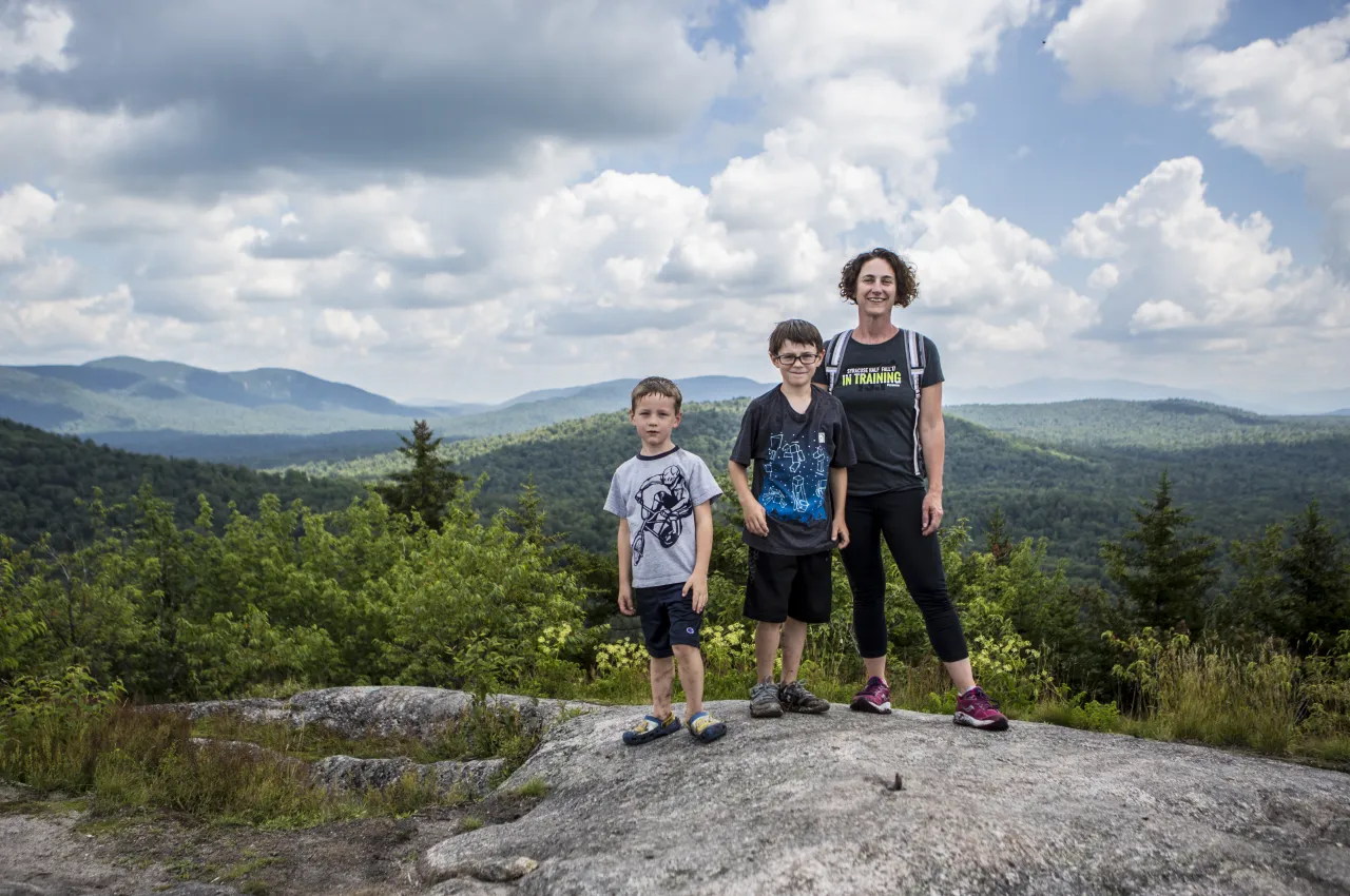 A woman and two boys stand on top of Coney Mountain.