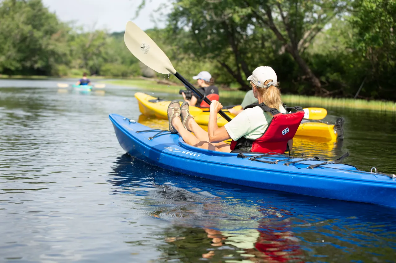 A group kayaks down the Raquette River.