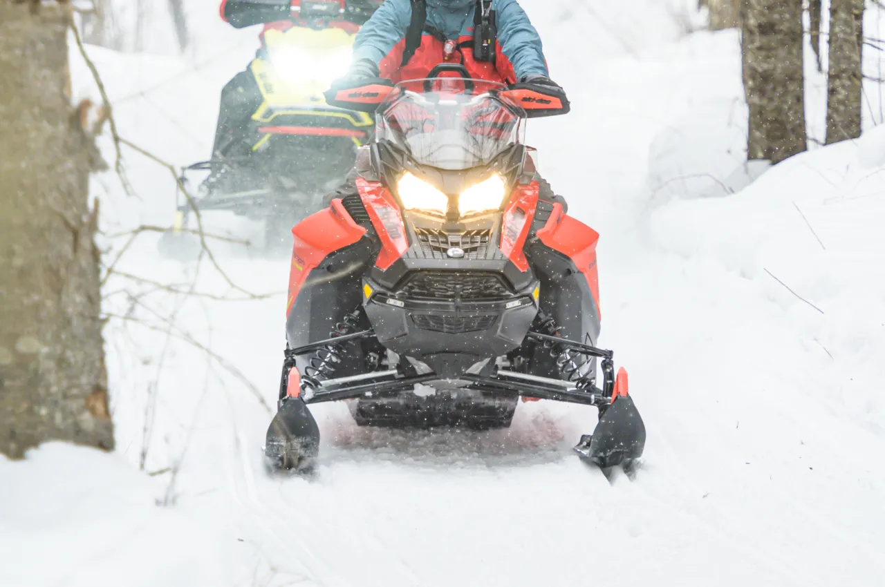 A snowmobile heading down the trail.