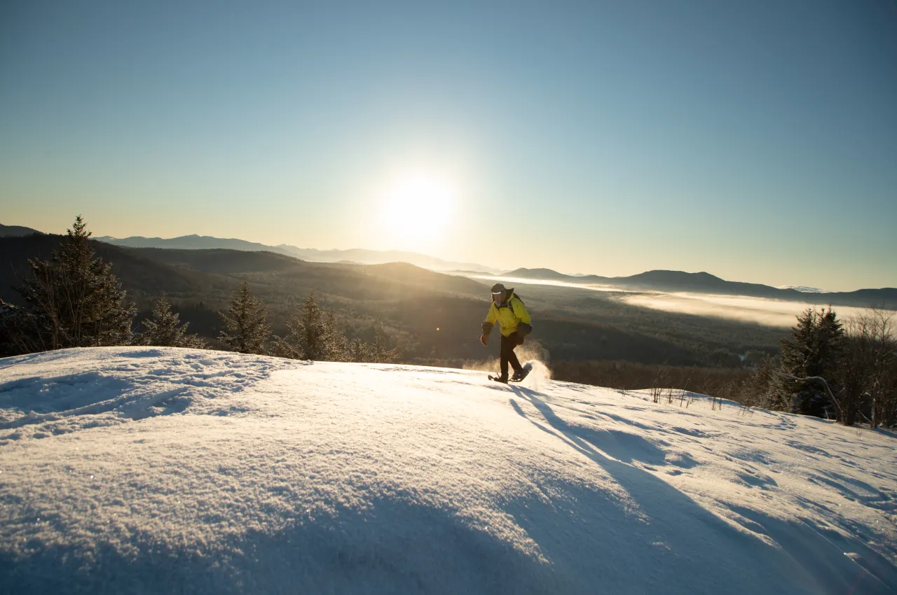 A man on snowshoes approaches the summit of COney Mtn.