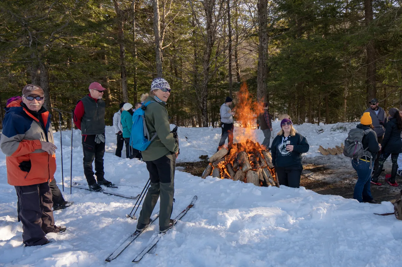 A group at Brew-Ski stands around a bonfire.