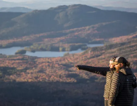 People pointing at things from top of mountain