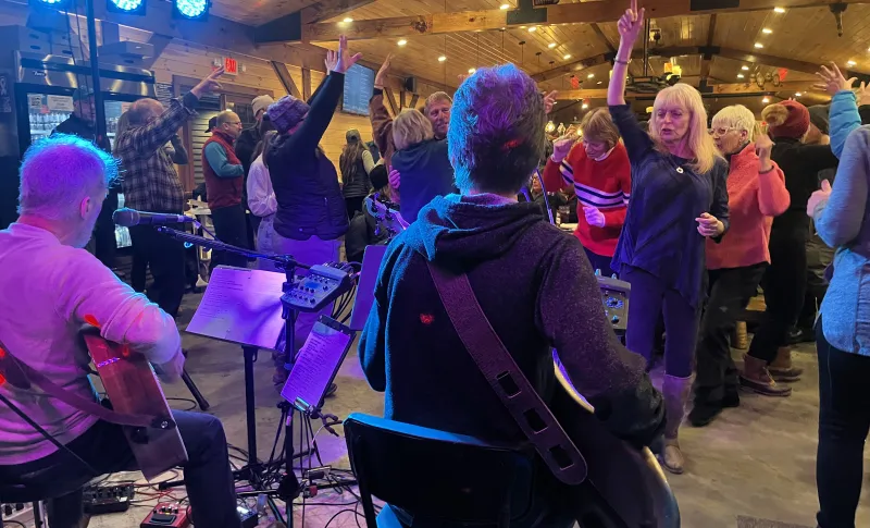 Band plays at Raquette River Brewing while people dance.