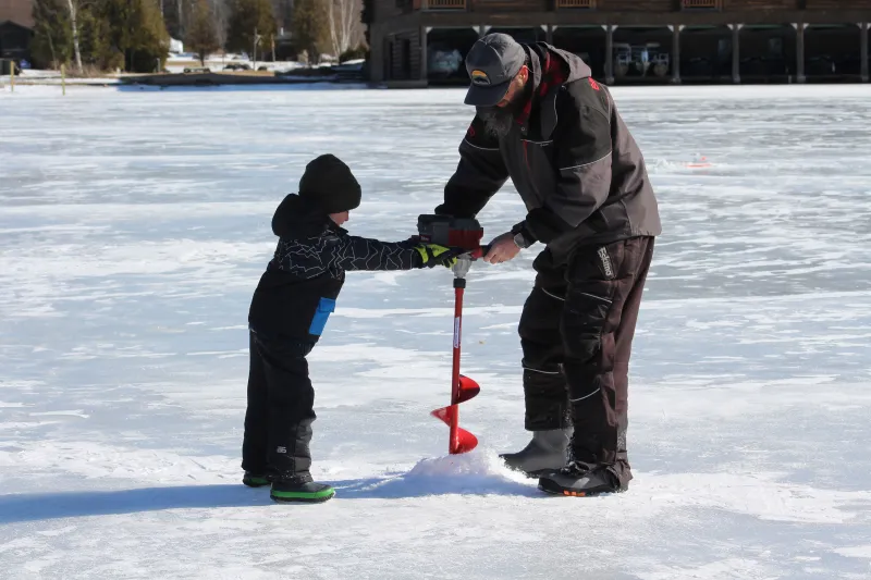 A guide with a young kid on the ice