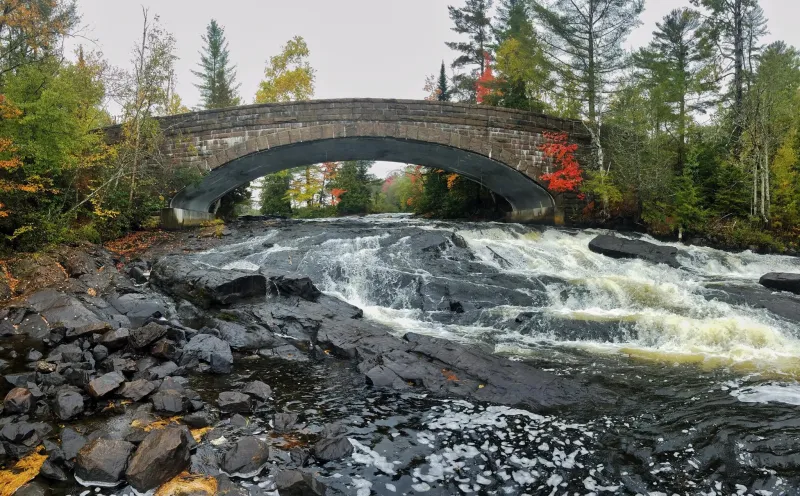 A stone bridge over a rocky waterfall