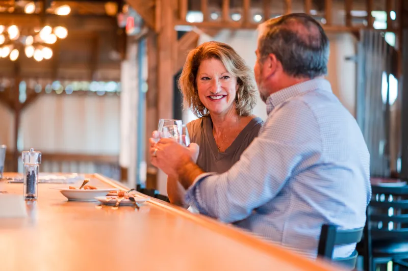 A man and woman clink cocktail glasses in a toast.