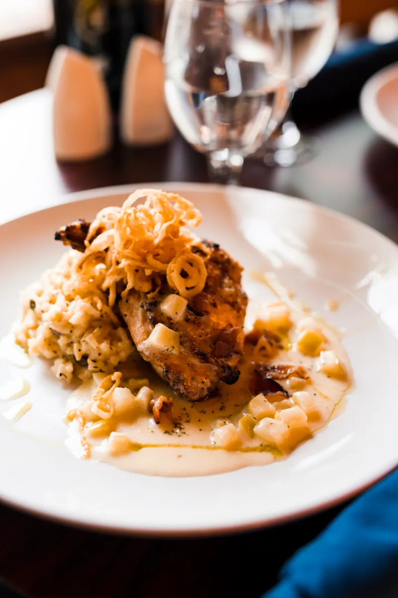 A close up of a pasta dish with roasted chicken.