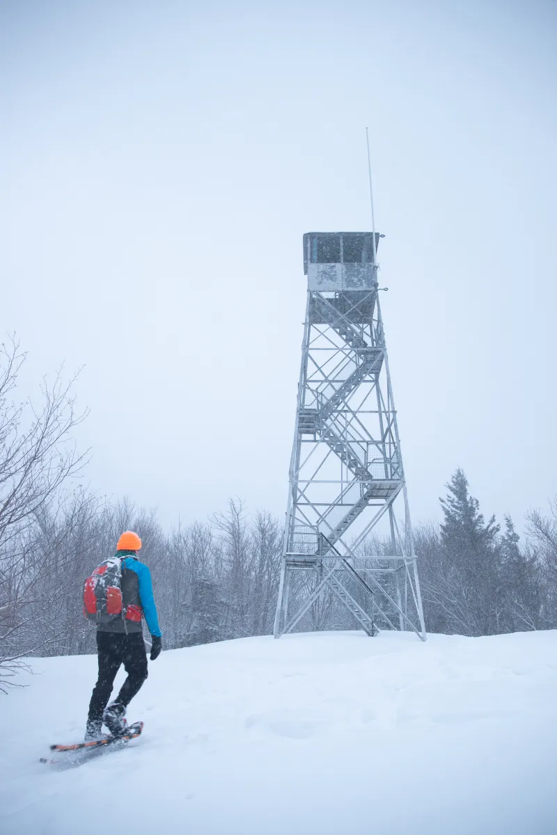 A hiker approaches the top of Mt Arab with the fire tower shown.