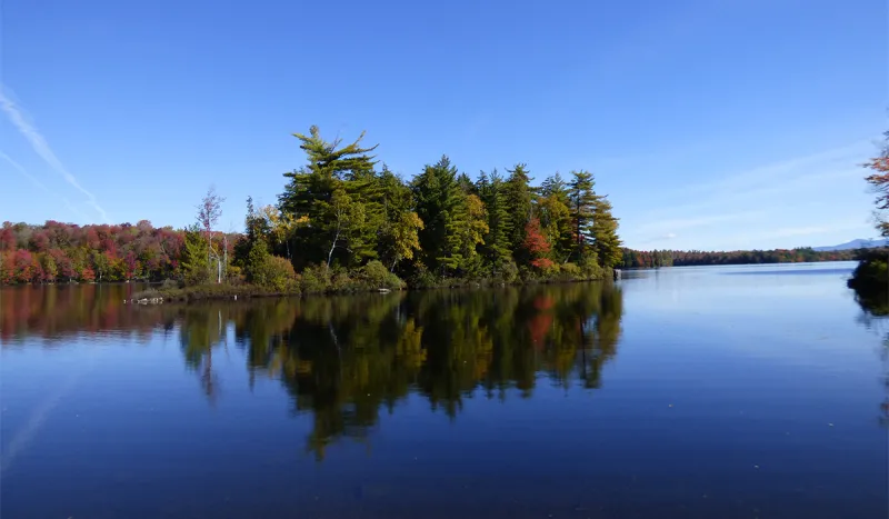 The autumn colors on Spider Island reflect off the glass like water of Piercefield Flow.