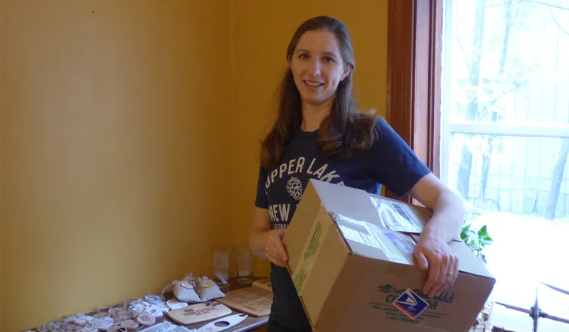 Store owner, Faith McClelland, carries one of the first of many boxes into what will soon be the Spruce & Hemlock Country Store