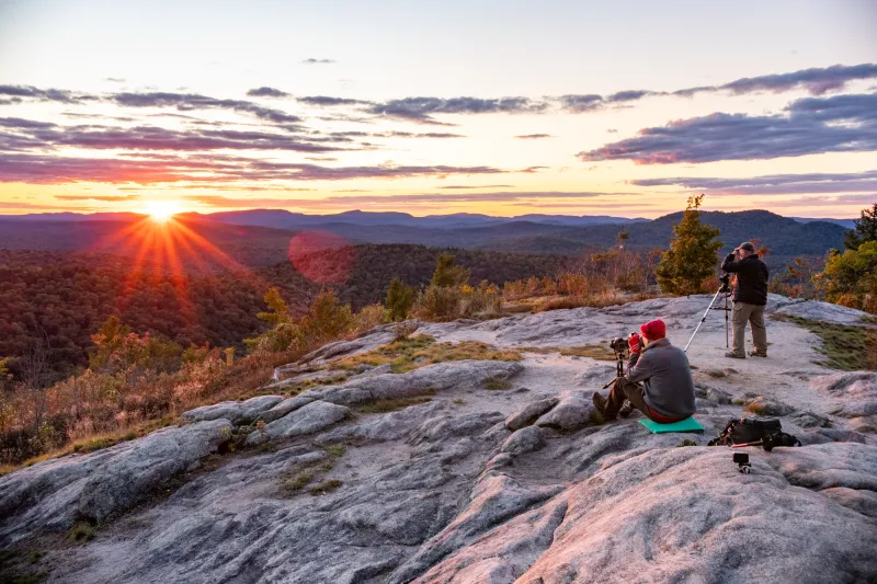 Two men photograph the sunset from the summit of Coney Mountain.