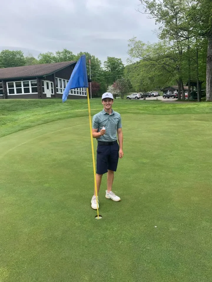 Nick standing next to the pin on the 18th hole.