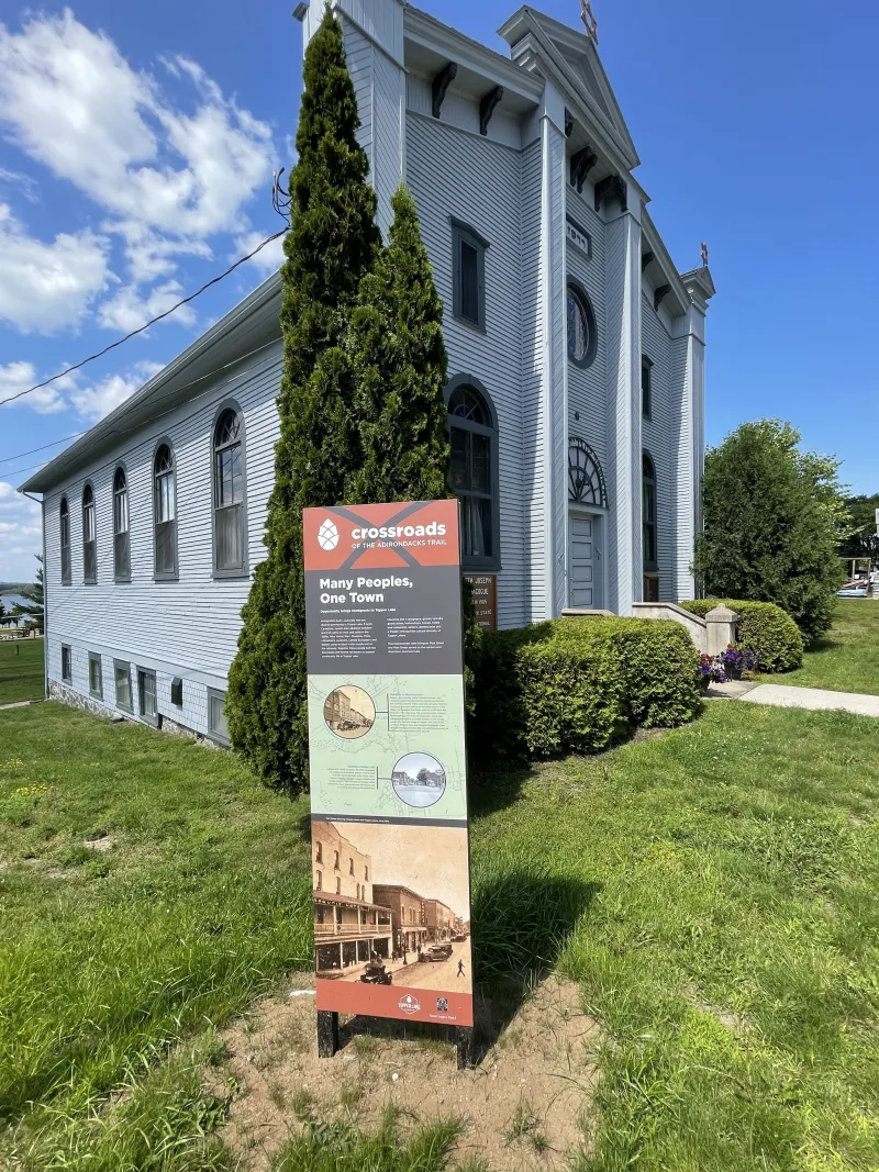 An informative trail sign in front of a historic synagogue.