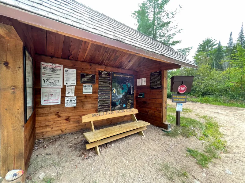 The informational sign-in lean-to at Massawepie with signs and posters on the wall.