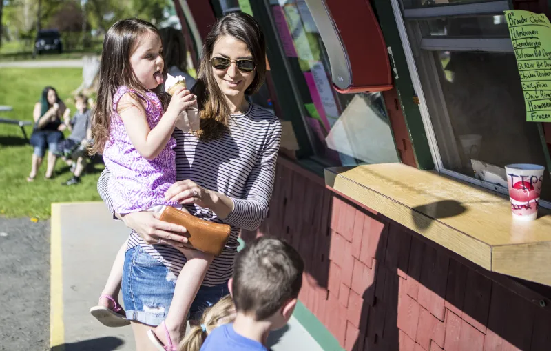 A mother and child order an ice cream cone at the window of Skyline Ice Cream.