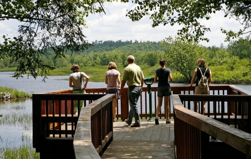 A family gazes out at the water from a large waterside structure