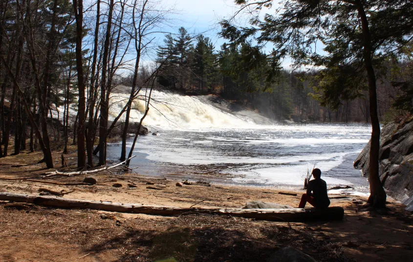 A waterfall by a flat shoreline