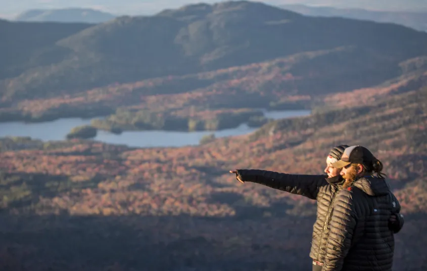 People pointing at things from top of mountain