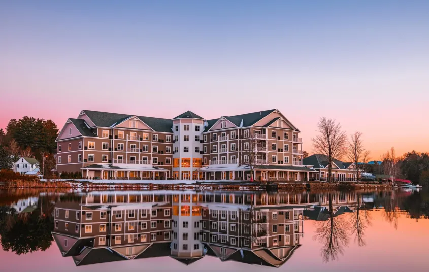 The exterior reflects off Lake Flower in a pink sunset