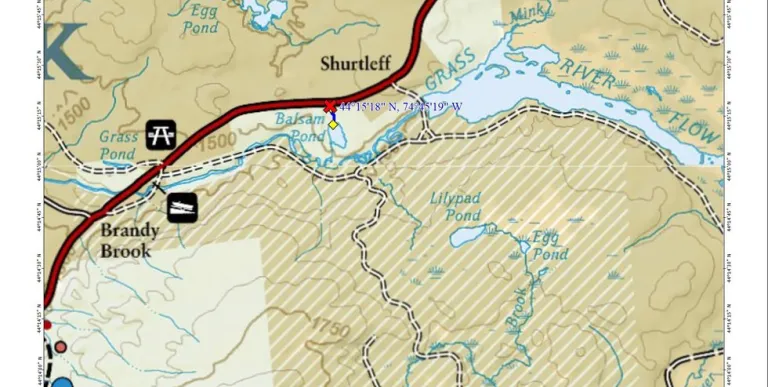 A map with a main road&#44; a narrow pond&#44; and some trails.