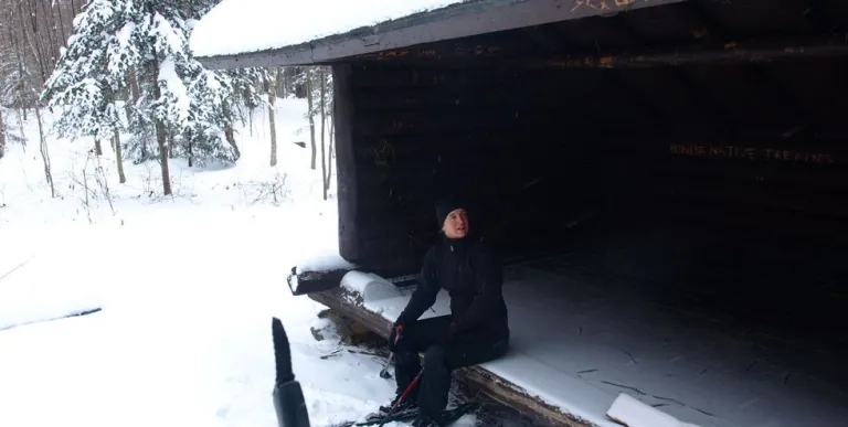 Someone sitting in a lean-to in the winter